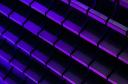 Photograph of neon purple and blue glowing bricks arranged in a 3D pattern against a dark background